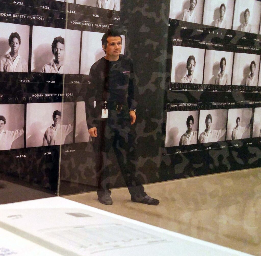 Guard in front of Basquiat portrait enlarged contact sheet.