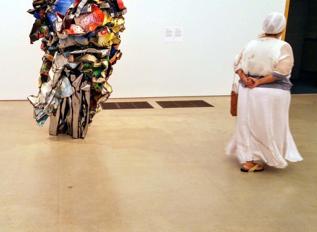 Woman with statue of car parts in museum