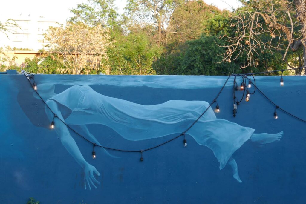 Mural wall of woman in dress suspended in water.