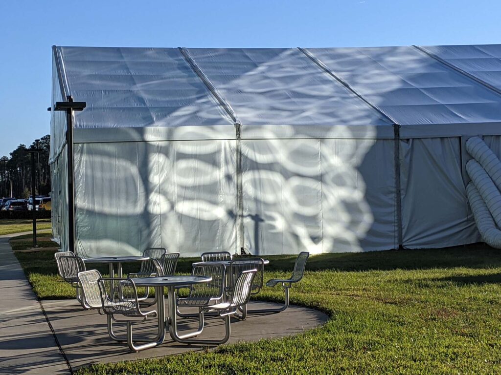 outdoor table and chairs in front of building with circular sun rays