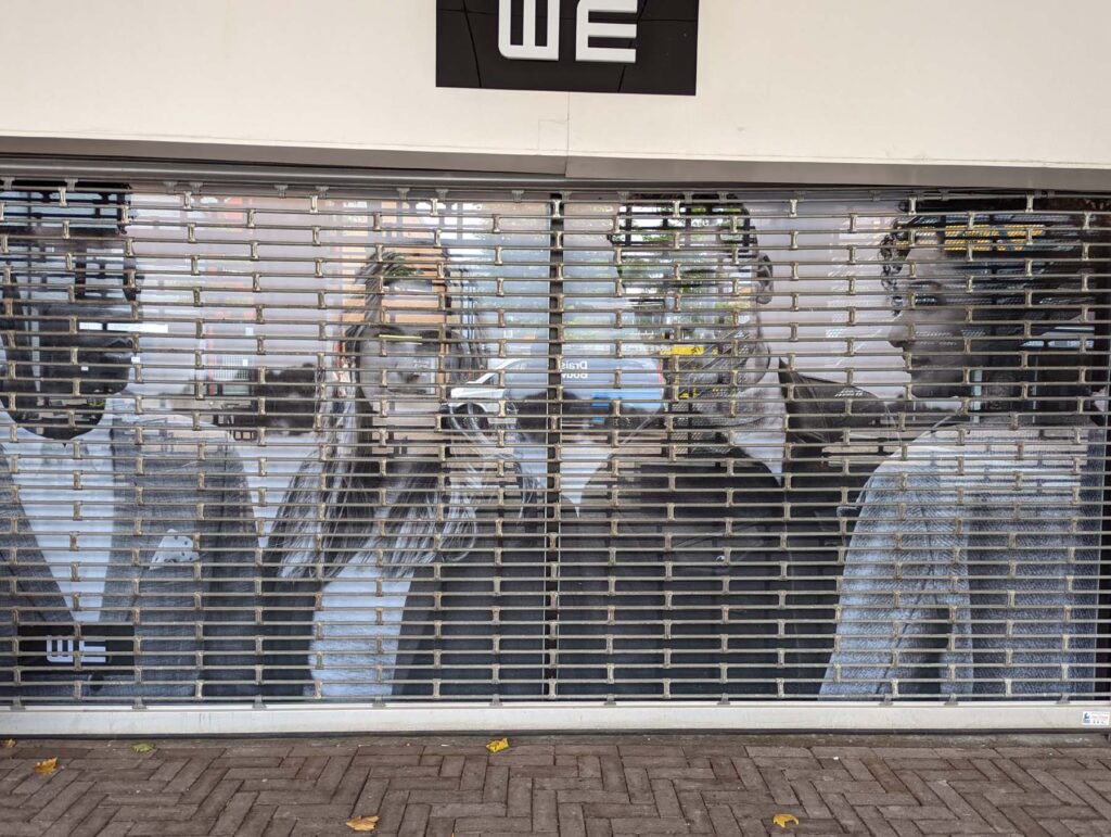 Painted figures behind fence.